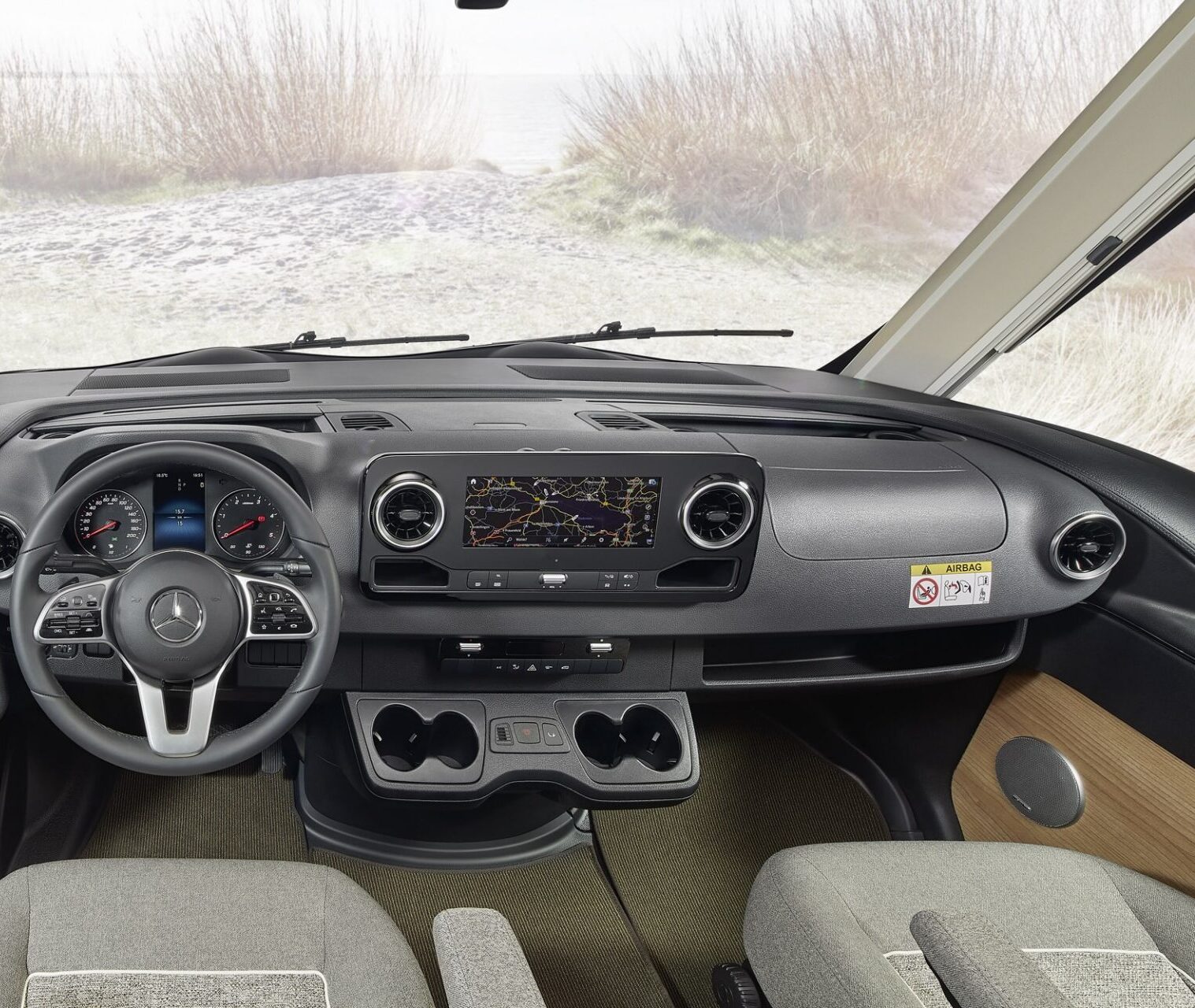 Fahrersicht eines Malibu Reisemobils mit Mercedes Benz Basisfahrzeug bei bewölkter Umgebung.