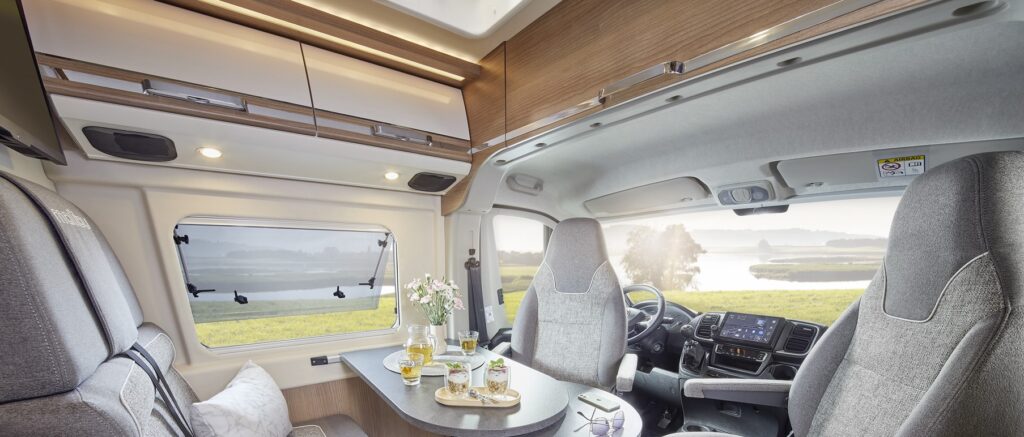Ansicht der Wohnsitzgruppe eines Malibu Campervans mit drehbarem Fahrer- und Beifahrersitz.