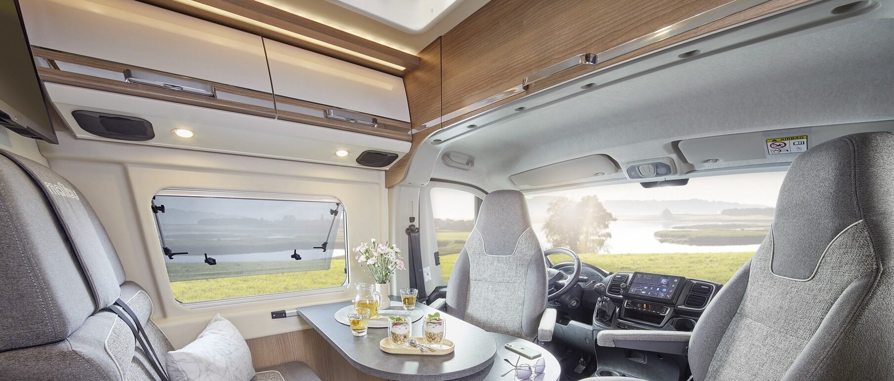 Ansicht der Wohnsitzgruppe eines Malibu Campervans mit drehbarem Fahrer- und Beifahrersitz.