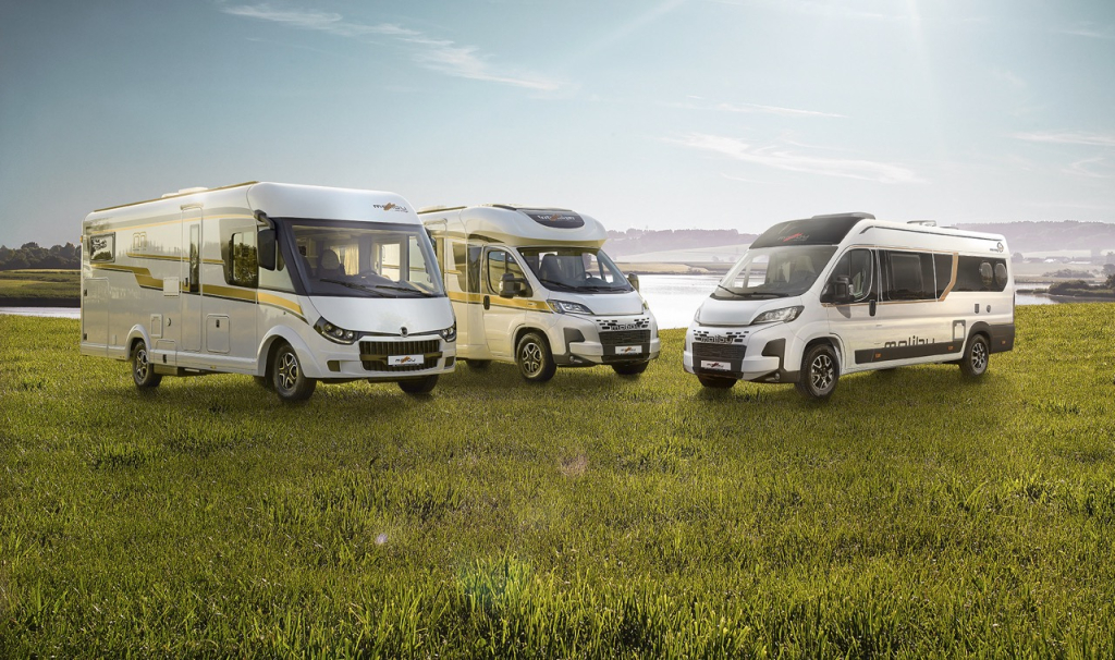 Malibu Reisemobile und Vans umgeben von grüner Landschaft