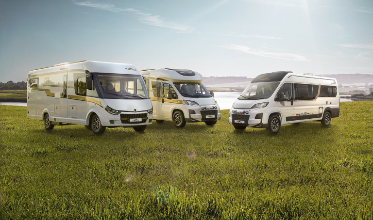 Malibu Reisemobile und Vans umgeben von grüner Landschaft