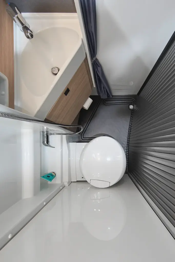 Salle de bains compacte avec toilettes et lavabo dans le camping-car Malibu Van : un concept d’espace astucieux pour les déplacements