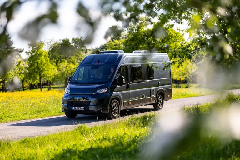 Malibu Relax Camper Van auf einer sonnigen Landstraße, ideal für preisbewusste Reisende, die Wert auf Design, Komfort und ein starkes Preis-Premium-Verhältnis legen