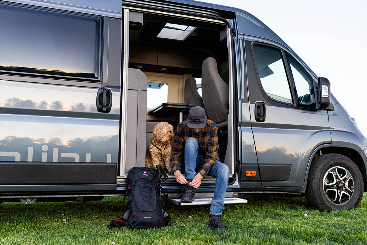 Malibu Relax Camper Van – Start in den Tag mit Hund, Wanderrucksack und geöffneter Schiebetür