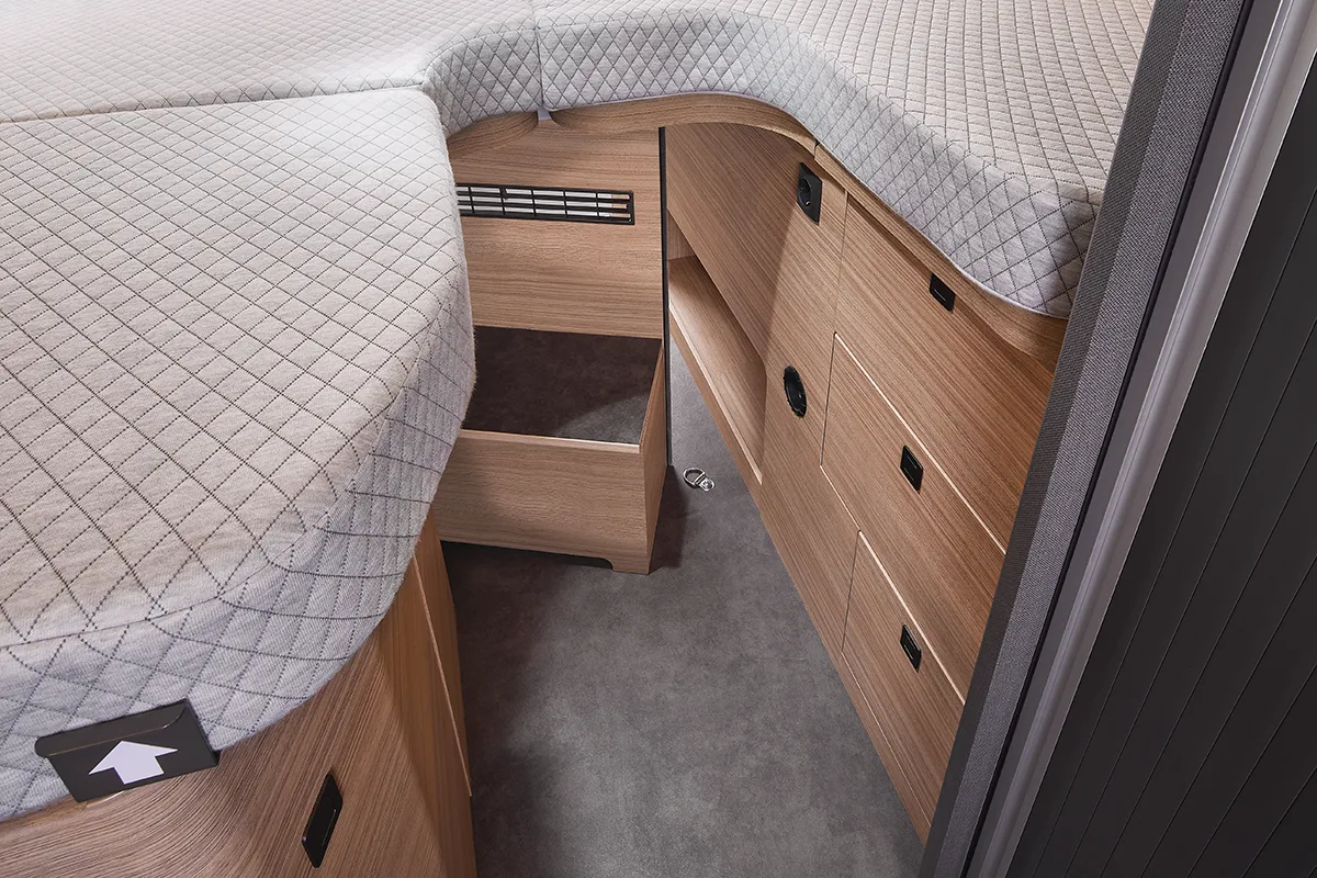 Offene Trittstufe mit integriertem Stauraum im Schlafbereich des Malibu Relax Camper Vans – durchdachtes Platzkonzept mit Schubladen