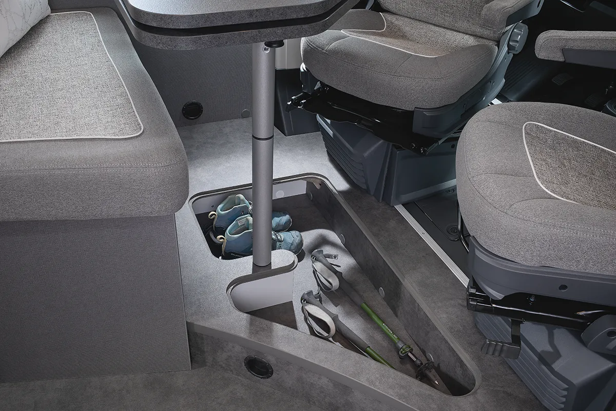 Praktischer Stauraum im Bodenbereich des Malibu Relax Camper Vans mit integrierter Ablage für Wanderschuhe und Trekkingstöcke