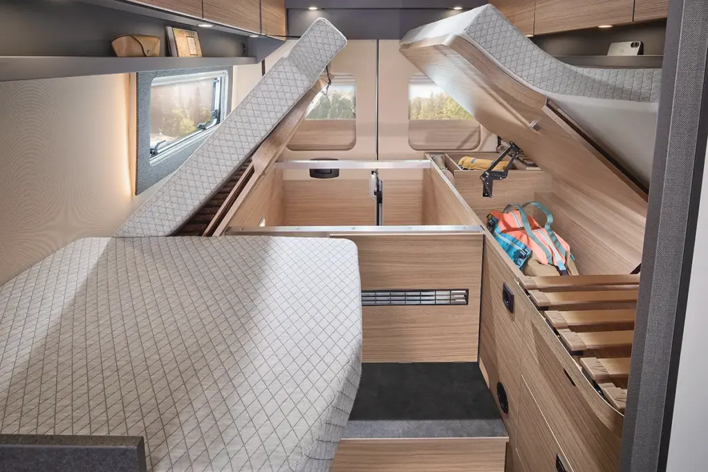 Espace de rangement ouvert sous les matelas du Malibu relax, avec des compartiments latéraux et des sangles