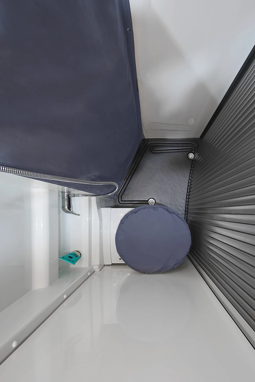 Duschbereich im Malibu Relax Camper Van mit geschlossenem Sichtschutzvorhang und abgedeckter Toilette für mehr Privatsphäre