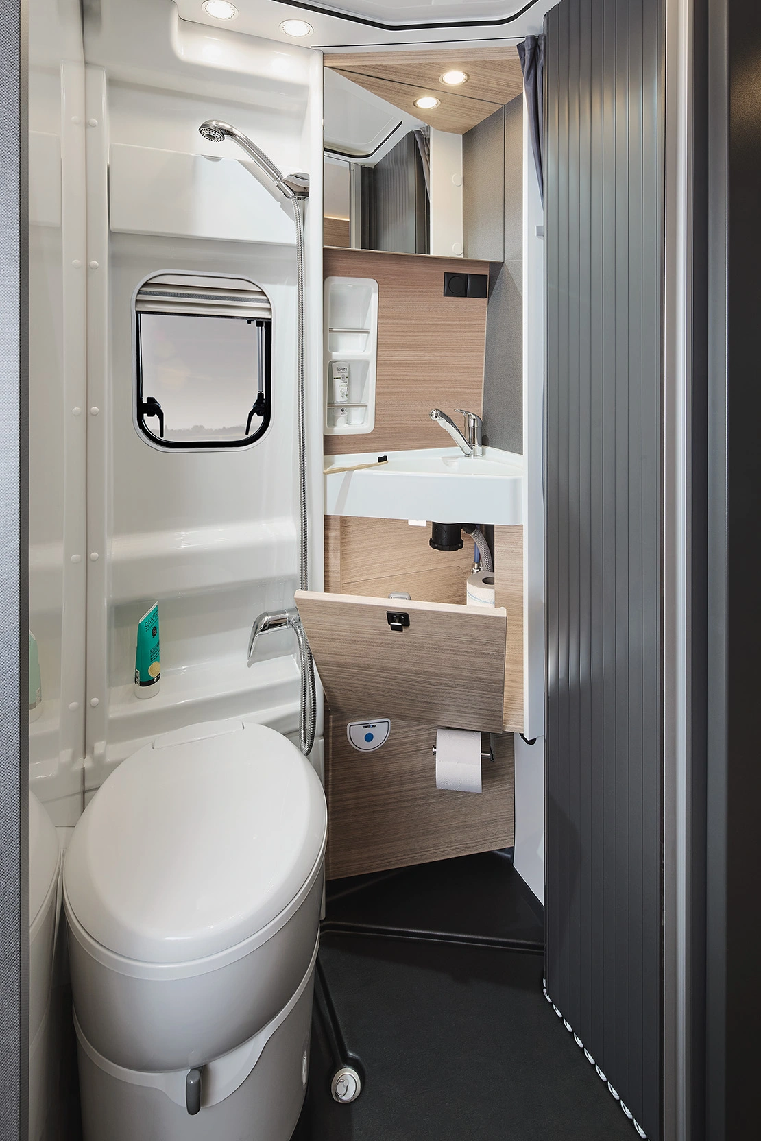 Modernes Bad im Malibu Relax Camper Van mit Waschbecken, Spiegelschrank, Dusche und Tageslichtfenster für ein luftiges Raumgefühl