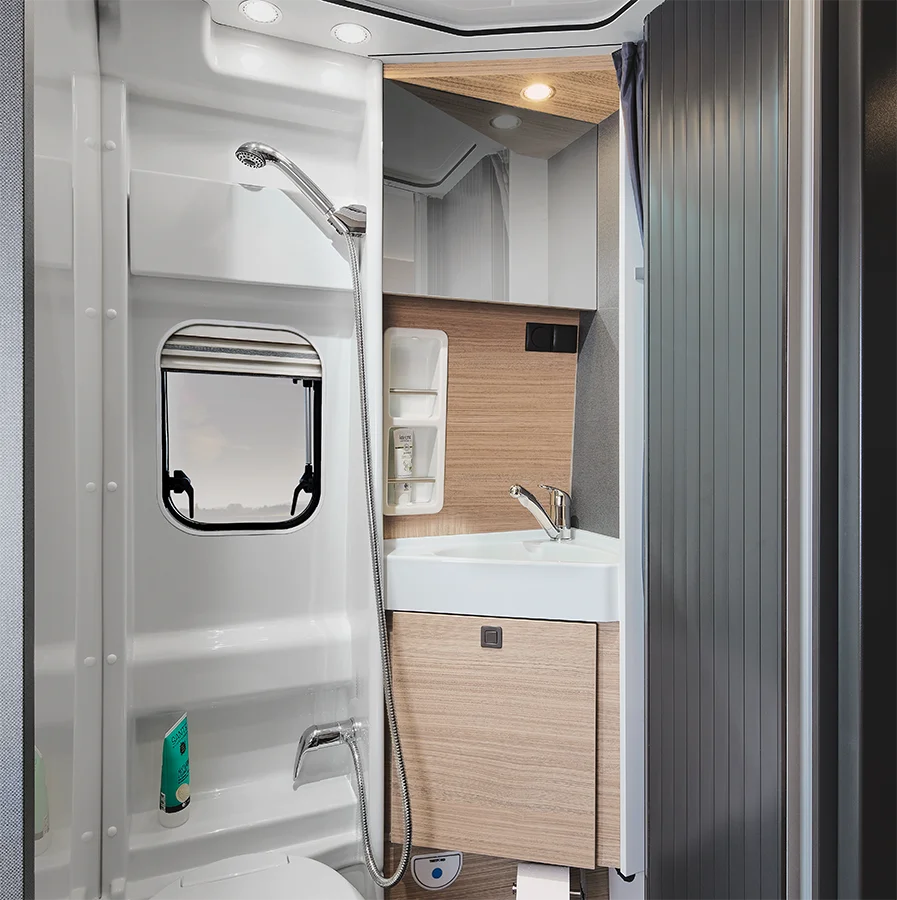 Blick in das funktionale Bad des Malibu Relax mit Dusche, Waschbecken, Spiegelschrank und Tageslichtfenster