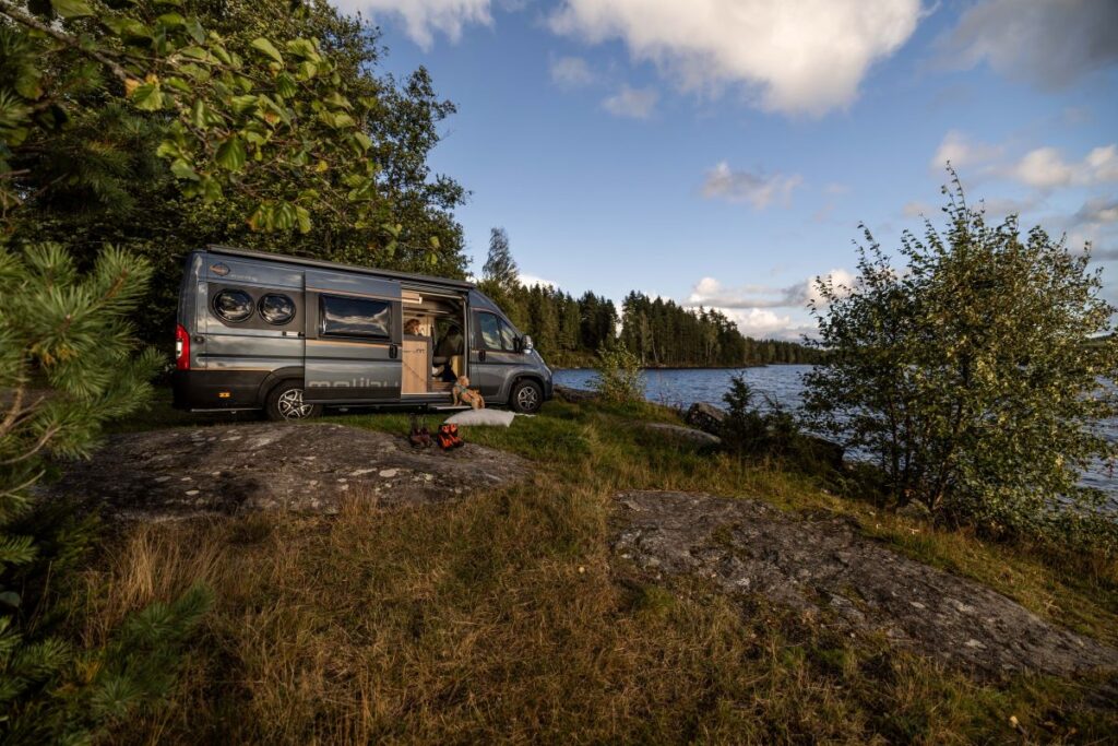 Ein MAlibu VAn steht auf einer Anhöhe vor einem See in Norwegen
