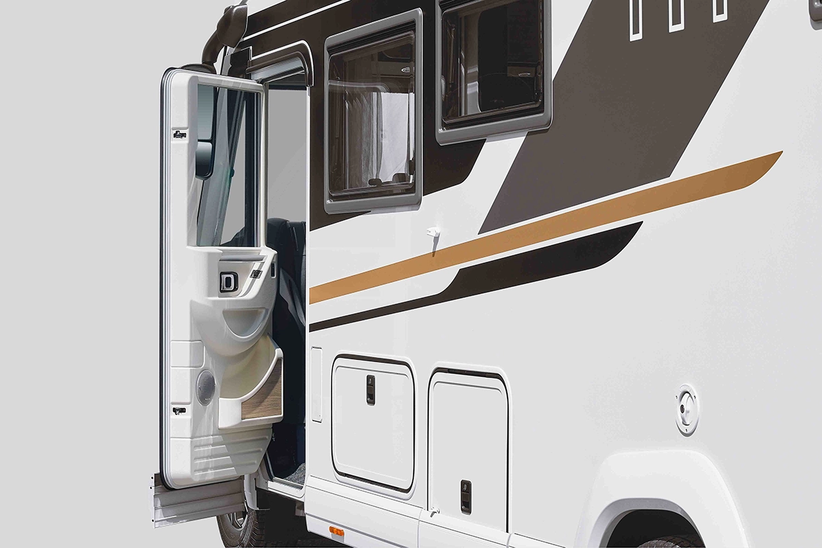 Ein weiß-braunes Wohnmobil mit geöffneter Seitentür, die einen Teil des Innenraums freigibt. Das Äußere weist Staufächer und Fenster auf. Der Hintergrund ist einfarbig und hellgrau.