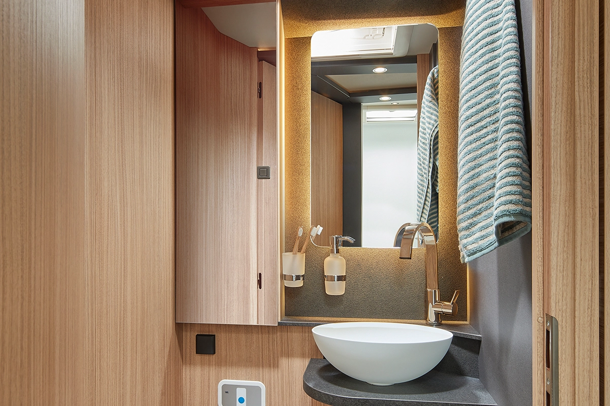 Geräumiger Waschtischunterschrank mit Toilettenpapierhalter, Aufsatzwaschbecken, großer Spiegelstauschrank und Spiegel mit indirekter LED-Beleuchtung (Modelle comfort 4.2 t) sowie Dachluke Mini-Heki