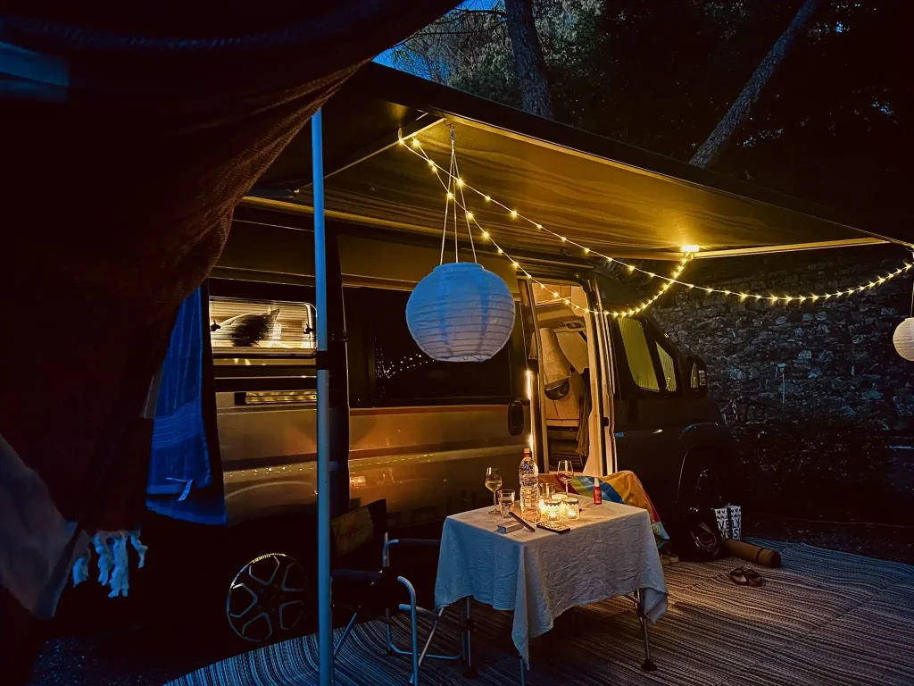 Stellplatz im dunkeln, mit Lichterkette und Campingtisch