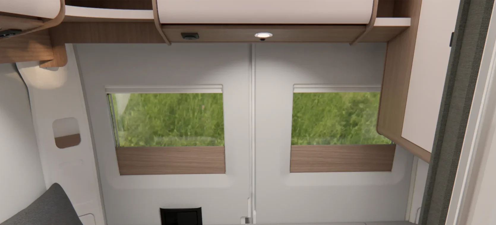 Innenansicht eines Malibu Campervans mit Querbett im Heck, sowie Heckfenstern.