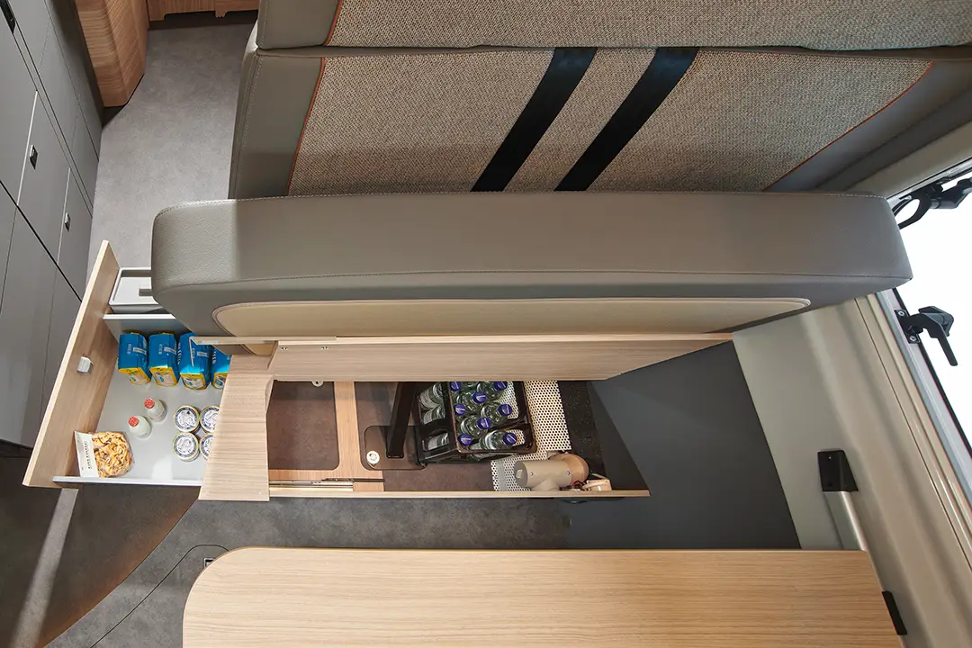 Ansicht des Stauraumes unter der Sitzgruppe eines Malibu Campervans, welche durch das Hochklappen der Sitzfläche bequem zugänglich ist.